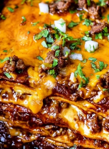 Delicious beef enchilada casserole topped with melted cheese and fresh ingredients
