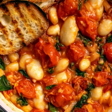 Creamy tomato basil butter beans dish served in a bowl with fresh herbs.