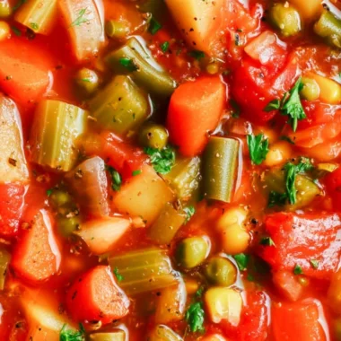 Bowl of hearty vegetable soup with fresh vegetables and herbs