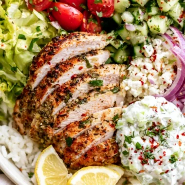 Delicious Lemon Herb Greek Chicken Bowl with fresh vegetables and lemon slices