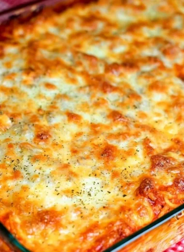 Delicious Ultimate Baked Spaghetti served in a bowl with melted cheese.