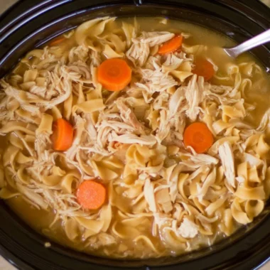 Bowl of high protein chicken noodle soup with vegetables and herbs