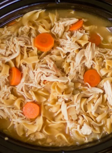 Bowl of high protein chicken noodle soup with vegetables and herbs