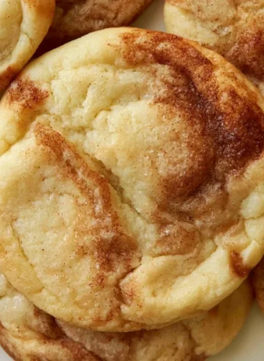Soft and chewy cinnamon roll cookies on a baking tray, topped with cinnamon sugar.