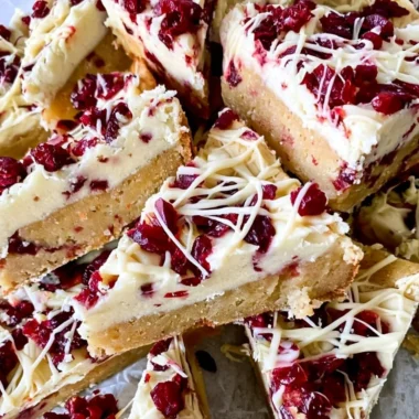Homemade Starbucks copycat Cranberry Bliss Bars with cream cheese frosting and cranberries.