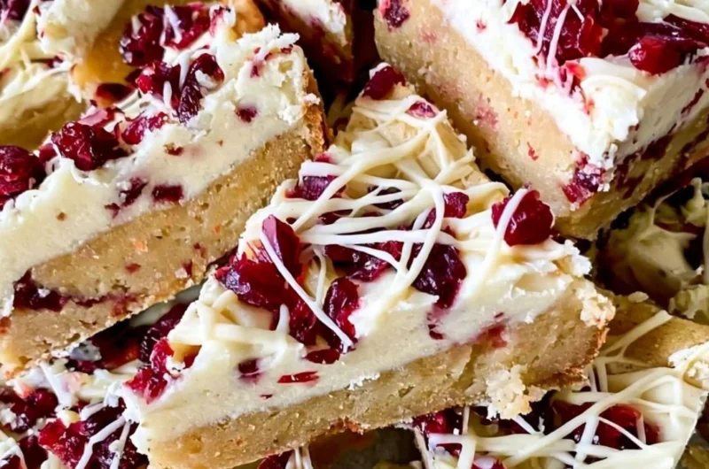 Homemade Starbucks copycat Cranberry Bliss Bars with cream cheese frosting and cranberries.